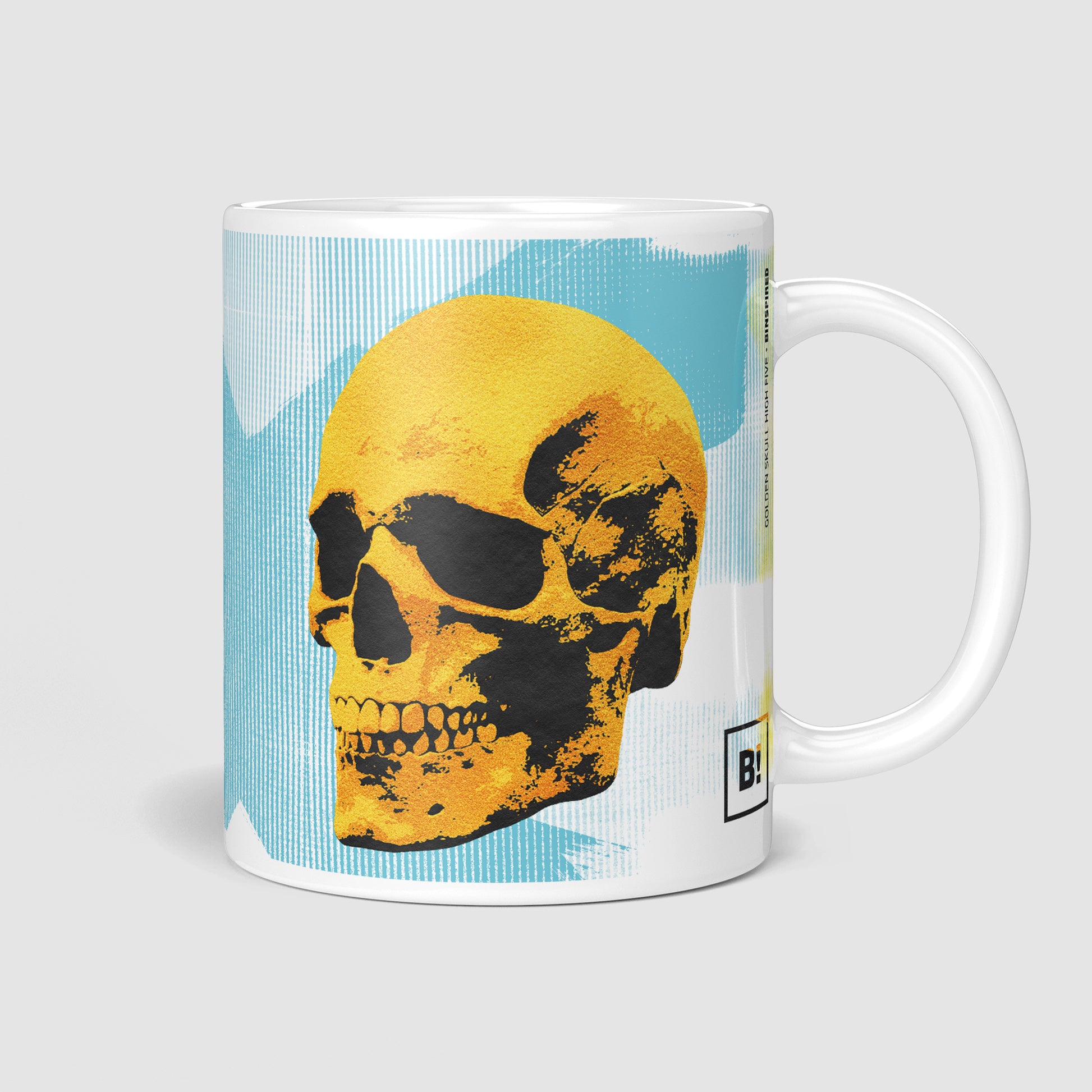 Side view of the 11oz Golden Skulls High Five coffee mug with the handle on the right, showcasing the vibrant pop art design of two golden skulls high-fiving against a light blue abstract background.