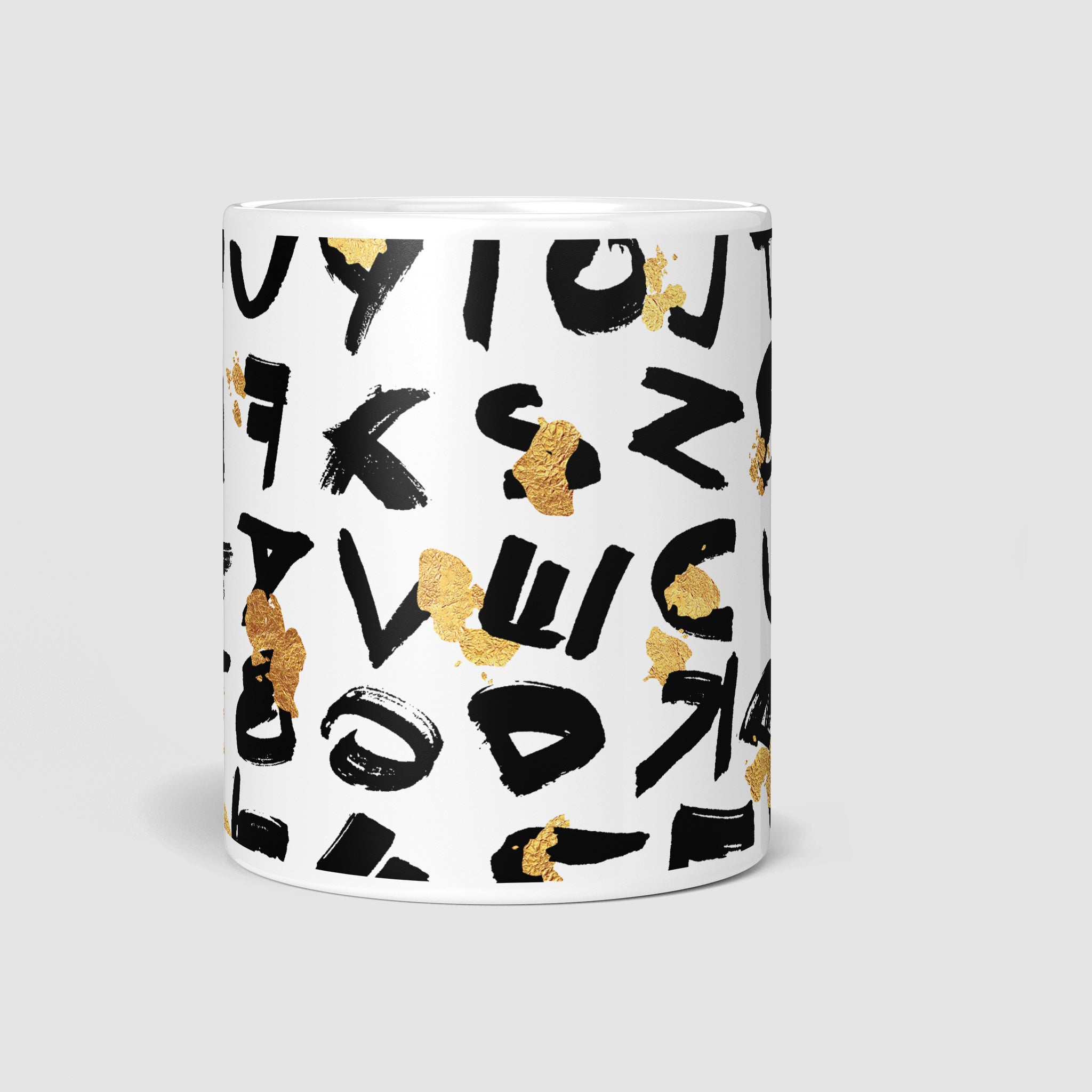 Front view of the 11oz coffee mug showcasing its striking design of black random lettering and golden splatter, a perfect representation of beautiful morning chaos.