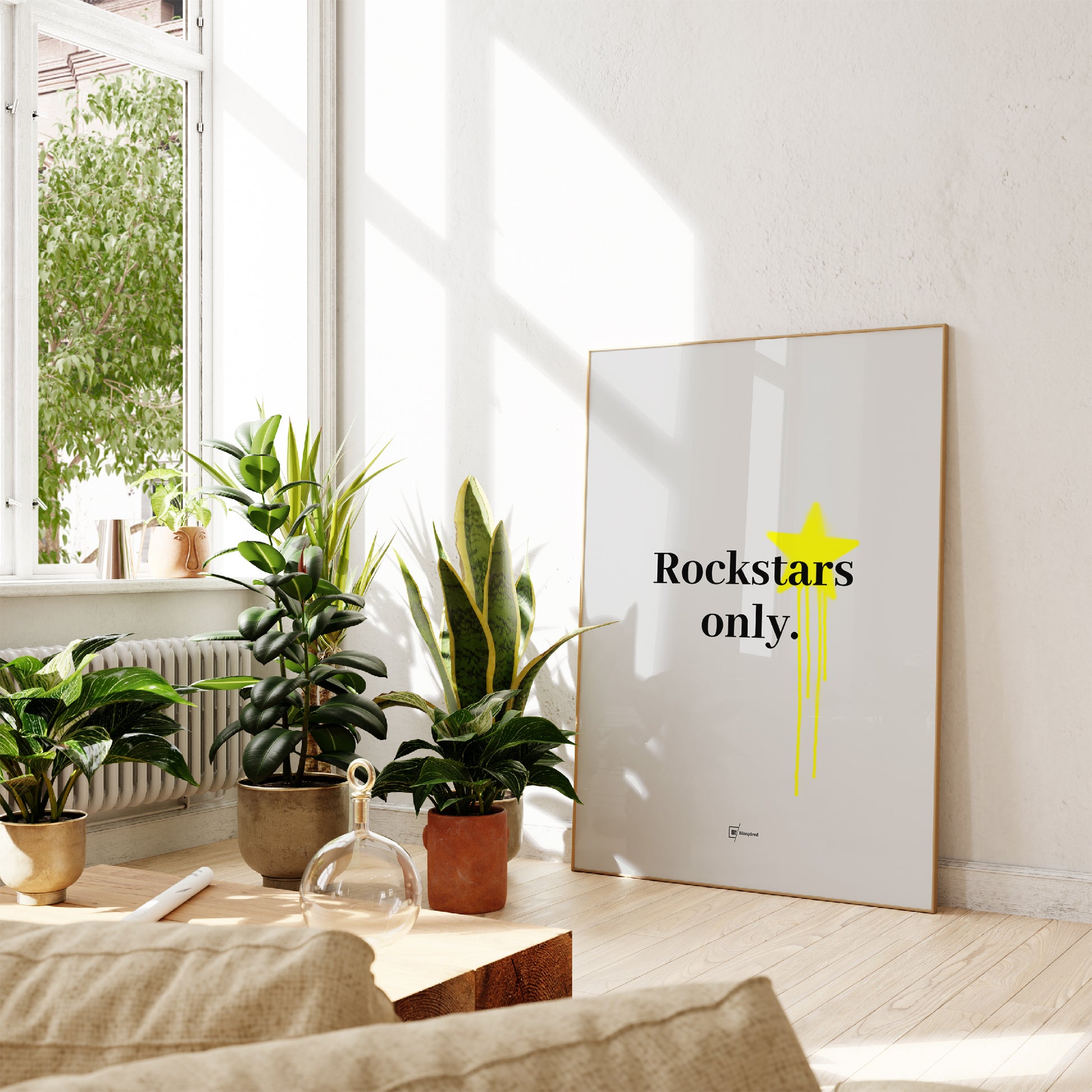 Framed "Rockstars Only" art print displayed on a gray wall in a modern living space, showcasing its bold black lettering and yellow graffiti details.