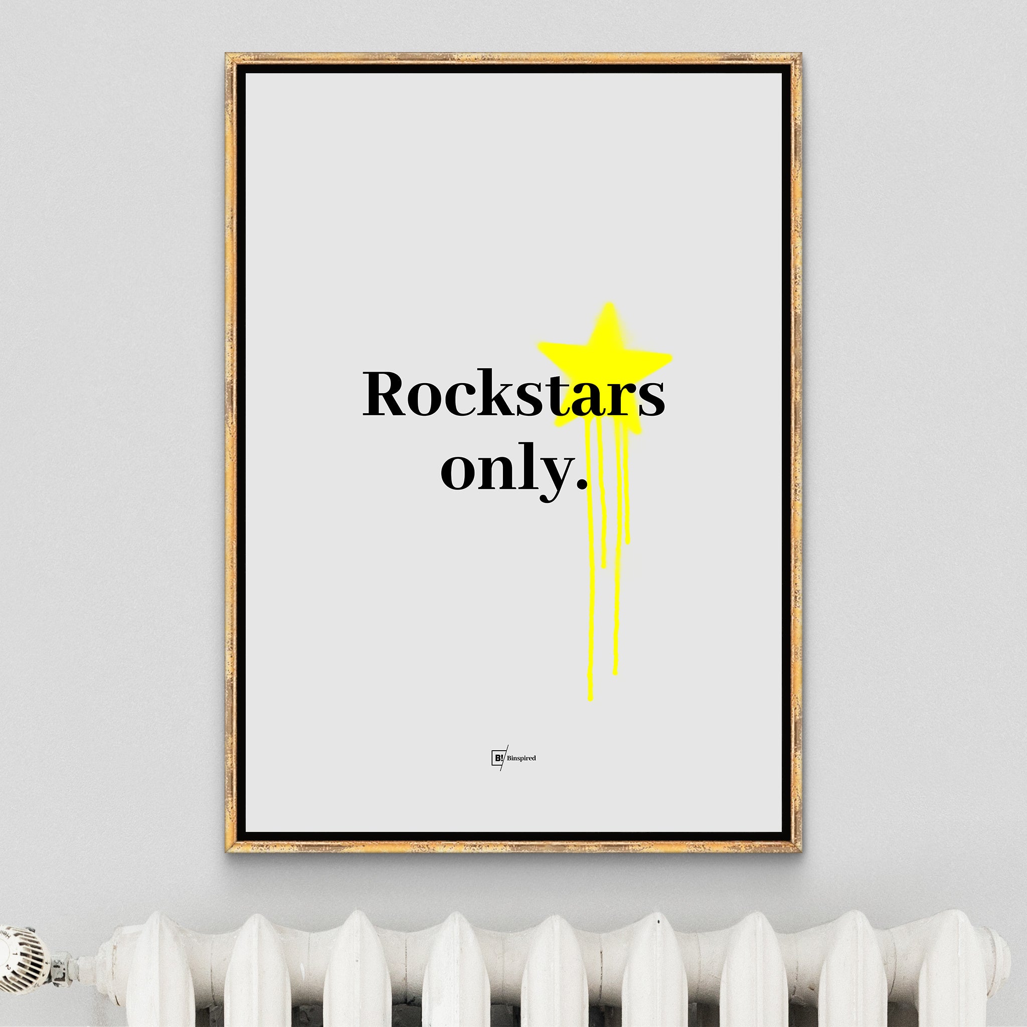 Rockstars Only art print in an antique golden frame, featuring bold black text on a sleek gray background with yellow graffiti splatter, elegantly displayed above a classic white radiator for a blend of edgy and vintage styles.